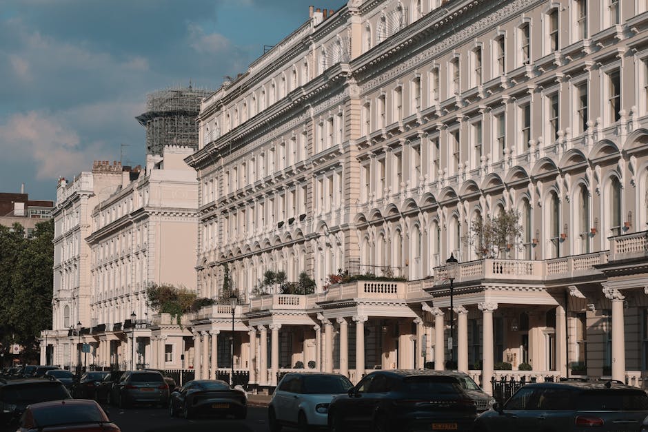A black and white photograph of a multi-story residential building facing Regent's Park, featuring a brick facade with white accents and multiple small balconies with metal railings. The ground floor